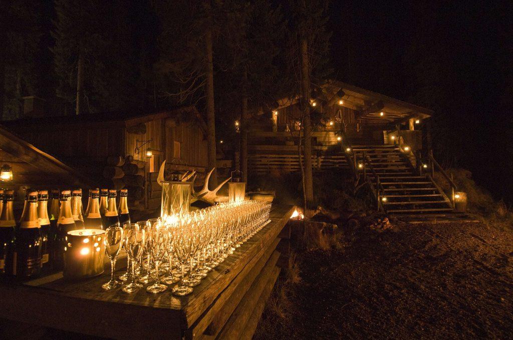 shampanjalasit rivissä, erämaaruokailu kynttilöin koristeltuna